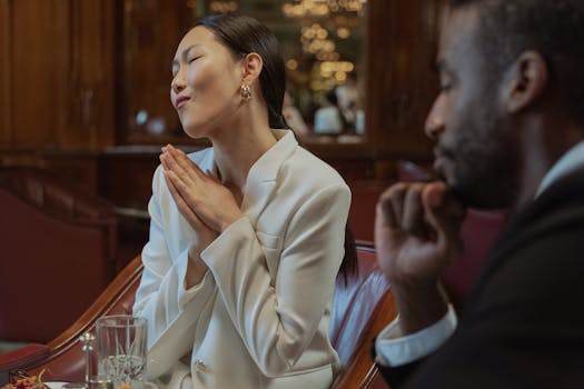 An Asian woman and Black man engaging in a thoughtful business discussion indoors.